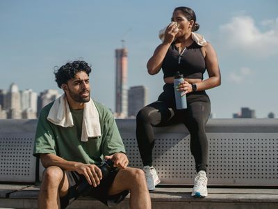 Water bottle and towel on a bench in a gym.